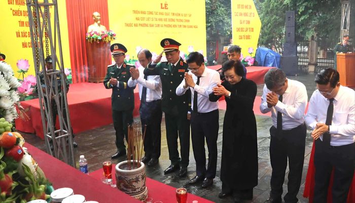  Các đại biểu thắp hương trước khi khai quật hài cốt liệt sĩ. Ảnh: HỮU PHÚC 