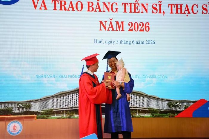 Một tân Thạc sĩ cùng con lên bục giảng nhận bằng tốt nghiệp.