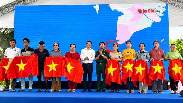 Ban tổ chức trao cờ Tổ quốc và những phần quà ý nghĩa đến ngư dân, động viên bà con vươn khơi bám biển.