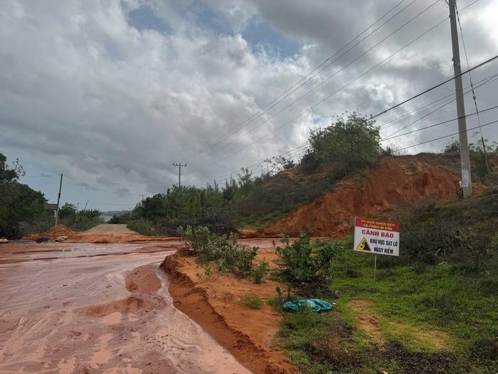 Một lượng lớn đất, đá và cát đỏ từ đồi cao tràn xuống tuyến đường ĐT716, gây ảnh hưởng đến việc đi lại của người dân và các phương tiện lưu thông qua khu vực.