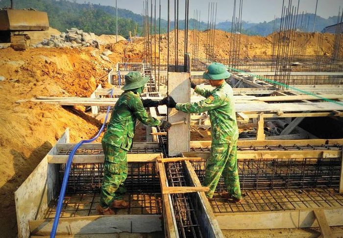 Cán bộ, chiến sĩ Đồn Biên phòng Đăk Pring tăng cường lực lượng hỗ trợ công trường, góp phần đẩy nhanh tiến độ xây dựng