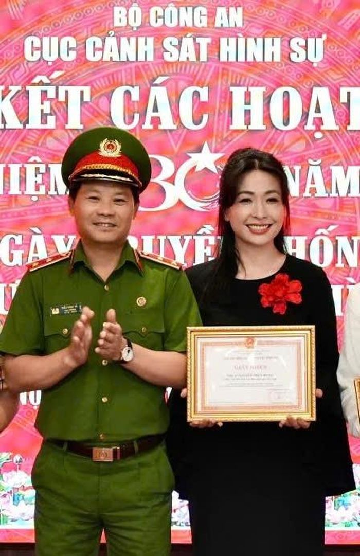 Trung tướng Trần Ngọc Hà - Cục trưởng Cục Cảnh sát hình sự trao giấy khen cho ca sĩ Thùy Dung.