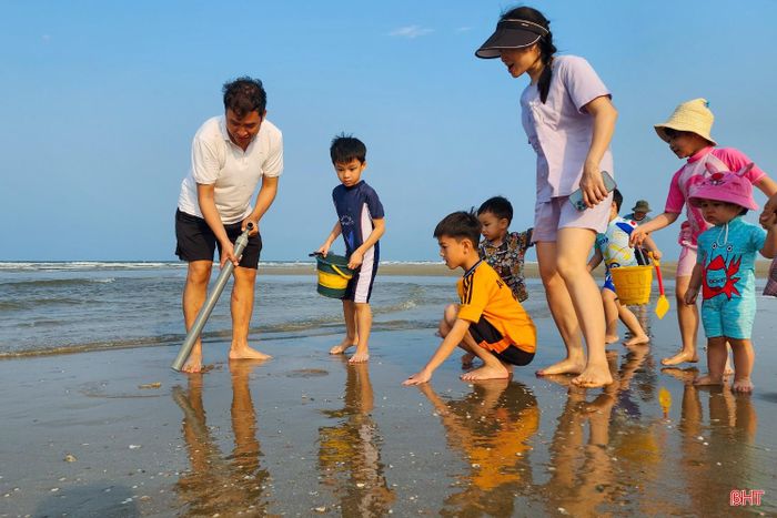 Khi phát hiện hang tôm tít, nhiều phụ huynh trực tiếp thao tác chiếc ống hút cát tự chế, đồng thời hướng dẫn con em cách "tóm gọn" những chú tôm vừa trồi lên khỏi mặt cát.