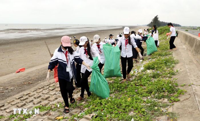 Học sinh dọn dẹp, vệ sinh môi trường biển ở Hải Hậu. (Ảnh: Nguyễn Lành/TTXVN)