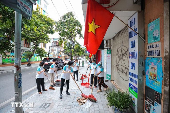 Các hội viên Chi hội Phụ nữ hăng say quét lá, thu dọn rác thải trên tuyến phố Cửa Bắc, thành phố Hà Nội. (Ảnh: Lê Đông/TTXVN)