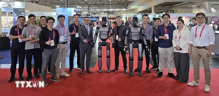 Đại sứ Việt Nam tại Áo Vũ Lê Thái Hoàng tham gia màn trình diễn của hai robot VR-H3 do VinRobotics sản xuất. (Ảnh: Vũ Hiệp/TTXVN)