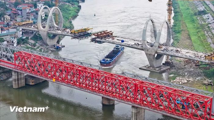 Công trình thể hiện sự giao thoa giữa hai thế hệ cầu: cầu đường sắt tái hiện dáng dấp cầu thép thời Pháp thuộc, còn cầu đường bộ mới ứng dụng công nghệ hiện đại, với thiết kế mềm mại, thanh thoát hướng đến tương lai. (Ảnh: Hoài Nam/Vietnam+)
