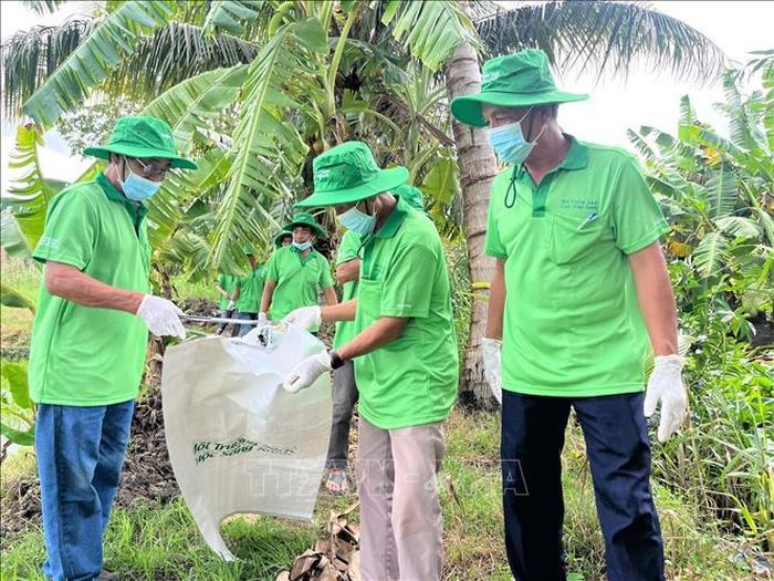 Thu gom bao bì thuốc bảo vệ thực vật trong vườn cây của người dân xã Vị Thanh 1. Ảnh: Thu Hiền/TTXVN