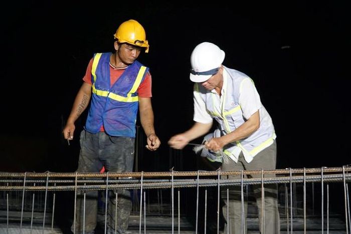 Các công nhân làm việc liên tục đến tối muộn để đảm bảo tiến độ công trình.