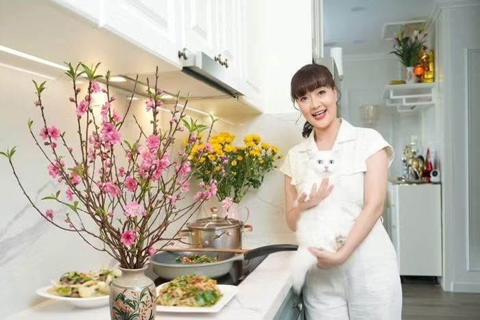  Căn bếp cũng được thiết kế theo phong cách hiện đại với gam màu trắng chủ đạo, mang đến cảm giác sang trọng và thoáng đãng. Hệ tủ bếp cao kịch trần có bề mặt bóng, kết hợp cùng mảng tường vân đá sáng màu giúp không gian thêm tinh tế và rộng rãi. Khu vực nấu nướng được bố trí gọn gàng, ngăn nắp 