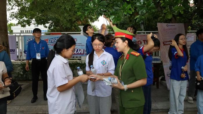 Nhằm góp phần tổ chức tốt kỳ thi quan trọng này, các lực lượng như công an, y tế, thanh niên tình nguyện... được phân công thường trực tại các điểm thi để hỗ trợ thí sinh và người nhà thí sinh. (Trong ảnh: Lực lượng tình nguyện viên tiếp nước cho thí sinh tại điểm thi Trường THPT Hàm Rồng).