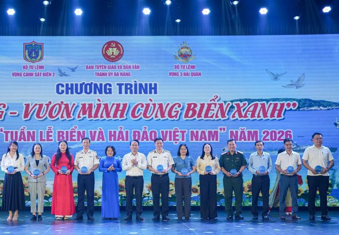 Phó Bí thư Thường trực Thành ủy Nguyễn Đình Vĩnh (thứ 6 từ trái qua) cùng Trưởng ban Tuyên giáo và Dân vận Thành ủy Huỳnh Thị Thùy Dung (thứ 5 từ trái qua) trao biểu trưng cho các cơ quan, đơn vị, địa phương tham gia chương trình “Đà Nẵng - Vươn mình cùng biển xanh”. Ảnh: T.CÔNG