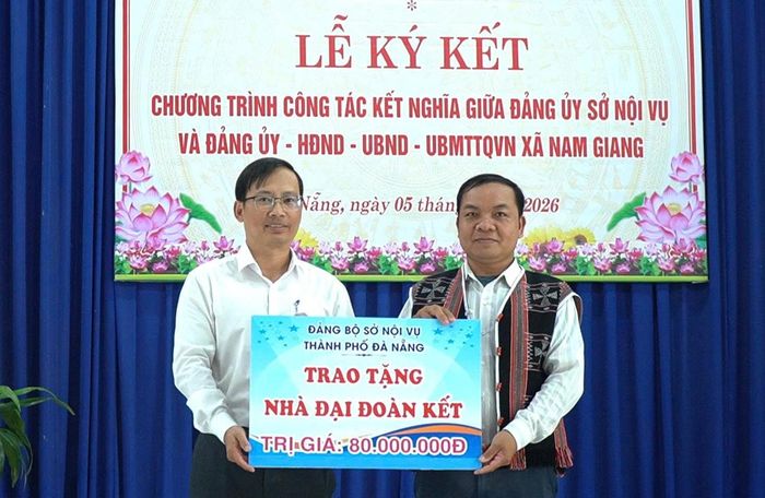 Phó Giám đốc Sở Nội vụ Hà Đức Hoài (bên trái) trao kinh phí hỗ trợ xây dựng nhà đại đoàn kết tại xã Nam Giang. Ảnh: PƠ LOONG PHÁI