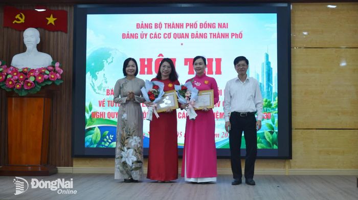 Ban tổ chức hội thi chúc mừng thí sinh: Trần Thị Hồng Lê, Chi bộ Ban Nội chính Thành ủy và Trần Thị Hồng Hạnh, Chi bộ Ủy ban Kiểm tra Thành ủy đoạt giải ba. Ảnh: Phương Hằng