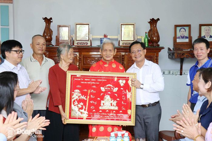 Ủy viên Ban Thường vụ Thành ủy, Phó Chủ tịch Thường trực Ủy ban MTTQ Việt Nam thành phố Hà Anh Dũng trao tặng khánh chúc thọ của Thành ủy - HĐND - UBND - Ủy ban MTTQ Việt Nam thành phố Đồng Nai cho cụ Trần Công Nghiêm ở khu phố 5, phường Đồng Phú. Ảnh: Ngọc Huyền