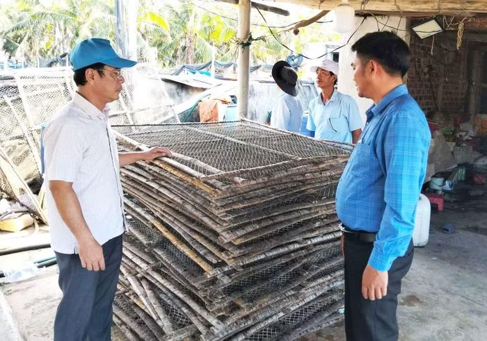  Ông Nguyễn Việt Cường (trái) cùng đại diện Phòng Kinh tế xã Đề Gi kiểm tra hiện trường các cơ sở sơ chế mực xà vào chiều 1-6. Ảnh: Văn Lực 