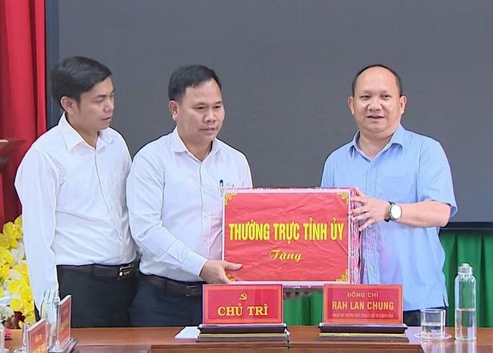  Phó Bí thư Thường trực Tỉnh ủy Rah Lan Chung (bìa phải) tặng quà của Thường trực Tỉnh ủy cho Ban Thường vụ Đảng ủy xã An Toàn. Ảnh: Trung Nghĩa 