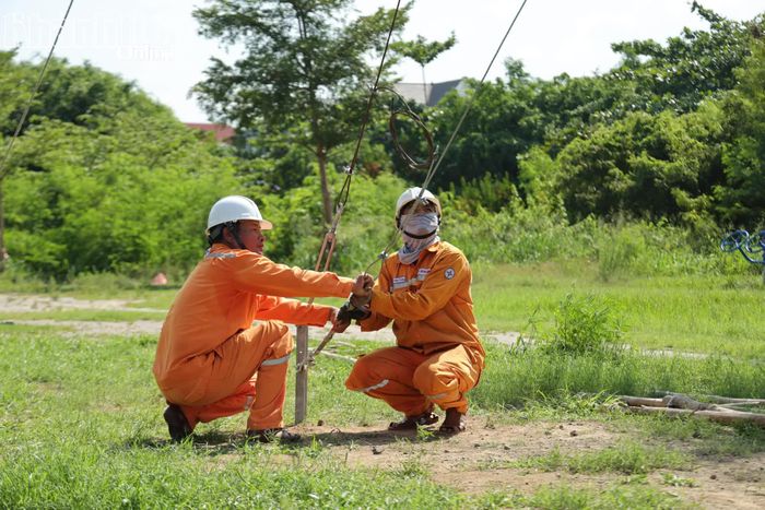 Nhân viên ngành Điện thực hiện kéo dây néo giữ cột tạm. 