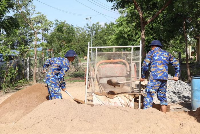 Cán bộ, chiến sĩ vận chuyển vật liệu xây dựng thi công căn nhà