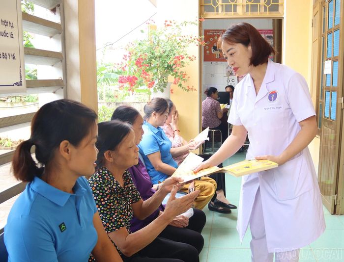  Cán bộ Trạm Y tế phường Âu Lâu phát tờ rơi truyền thông về phòng, chống bệnh cho Nhân dân. 