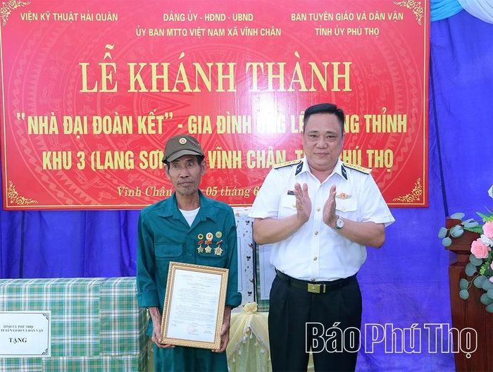 Đại tá Tô Hồng Quân - Bí thư Đảng ủy, Chính ủy Viện Kỹ thuật Hải quân trao quà tặng gia đình ông Lê Trọng Thỉnh.