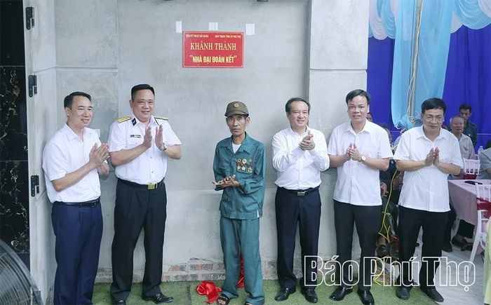 Các đại biểu thực hiện nghi thức khánh thành và bàn giao nhà Đại đoàn kết tặng gia đình ông Lê Trọng Thỉnh.