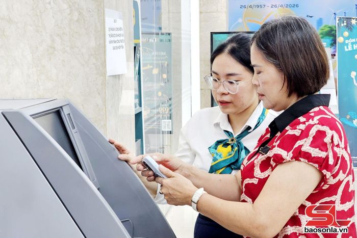 Nhân viên giao dịch BIDV Sơn La hướng dẫn khách hàng gửi, nộp tiền mặt trực tiếp trên máy CRM.