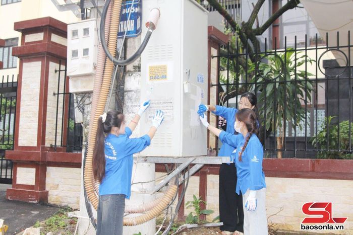 Đoàn viên, thanh niên bóc gỡ biển quảng cáo, tờ rơi, rao vặt trái phép trên tường rào quanh khu vực trường học.