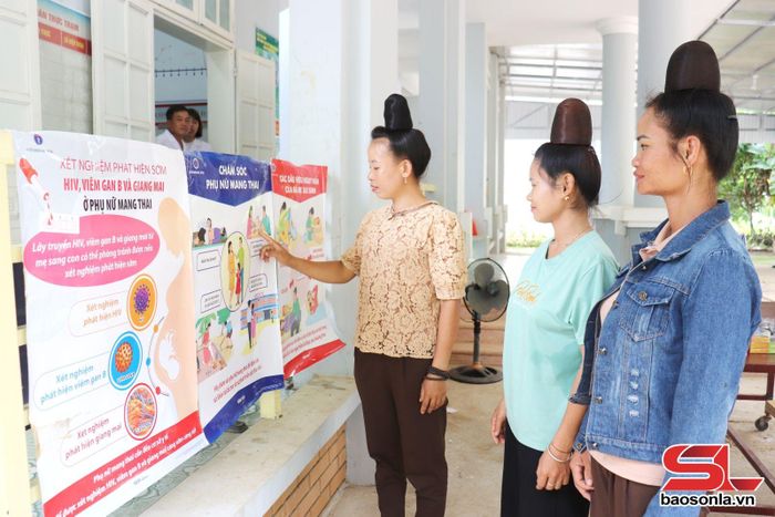 Phụ nữ xã Mường Lầm xem tờ rơi tuyên truyền.