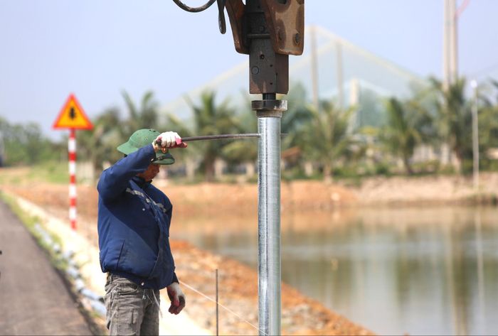 Công nhân đang tiến hành đóng cọc làm hộ lan thuộc gói thầu số 6 để đảm bảo an toàn cho người và phương tiện qua lại.
