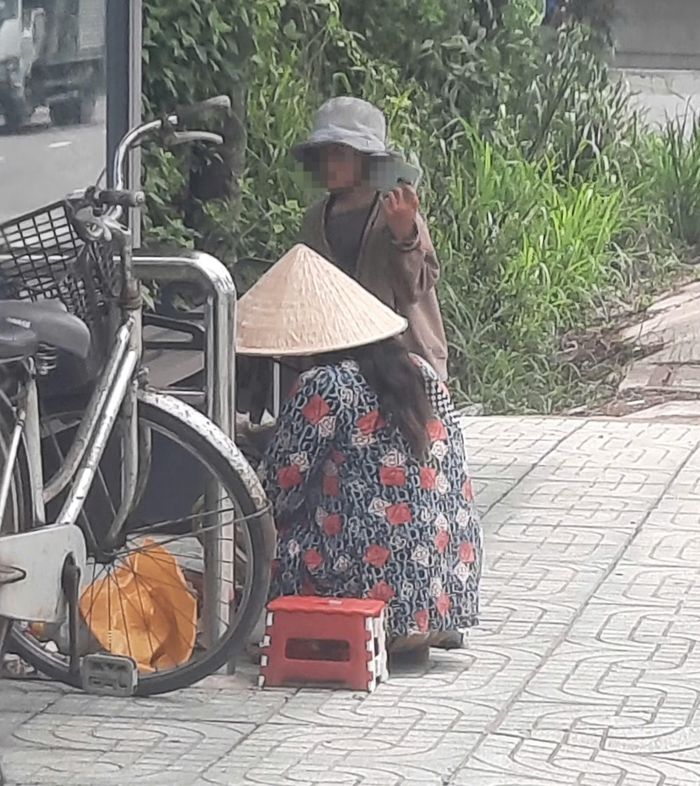  Đứa trẻ này được người lớn mang theo ra đường bán vé số 