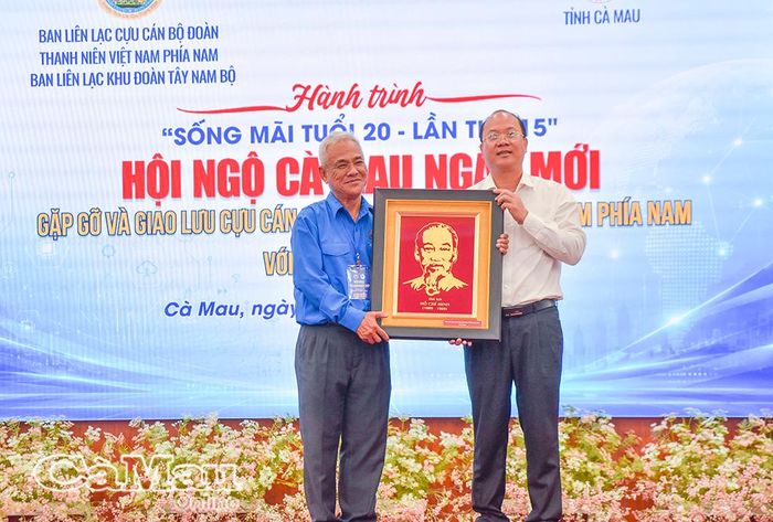 Đồng chí Nguyễn Hồ Hải, Ủy viên Ban Chấp hành Trung ương Đảng, Bí thư Tỉnh ủy, Trưởng đoàn Đại biểu Quốc hội tỉnh Cà Mau, tiếp nhận bức chân dung Chủ tịch Hồ Chí Minh từ Tiến sĩ Lê Hồng Liên, Trưởng Ban Liên lạc Cựu cán bộ Đoàn Thanh niên Việt Nam phía Nam, trao tặng. 