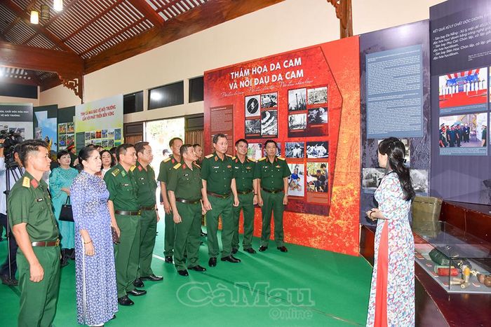 Đại biểu tham quan triển lãm hình ảnh và nghe thuyết minh viên giới thiệu về không gian triển lãm.