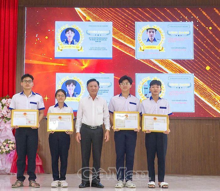 Phó Bí thư Thường trực Đảng ủy xã Long Điền Đặng Tấn Hùng trao bảng tuyên dương, khen thưởng các em đạt giải học sinh giỏi cấp quốc gia.