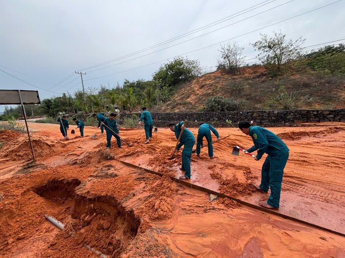 Lực lượng chức năng xã Phan Rí cửa dọn dẹp đất cát tràn xuống đường để người dân đi lại thuận tiện.