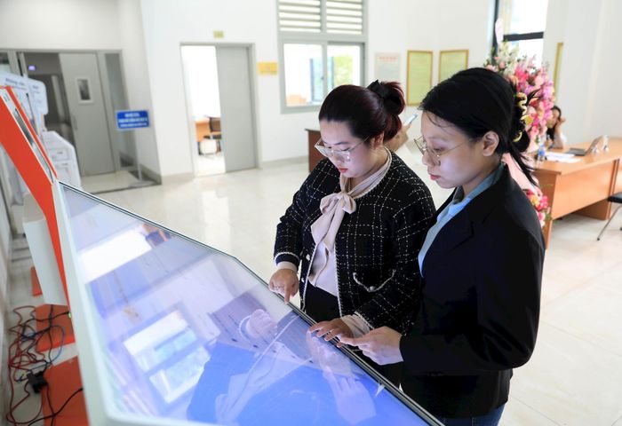Hỗ trợ người dân giải quyết thủ tục trên mạng tại Trung tâm Phục vụ hành chính công chi nhánh Cầu Giấy. Ảnh: Đỗ Tâm