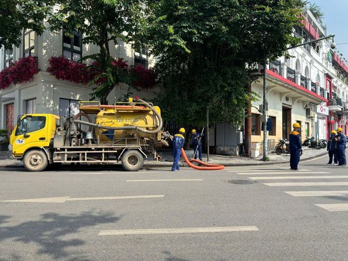 Xe chuyên dụng và lực lượng công nhân Xí nghiệp Thoát nước số 1 thực hiện duy trì, làm sạch hệ thống thoát nước. Ảnh: PV