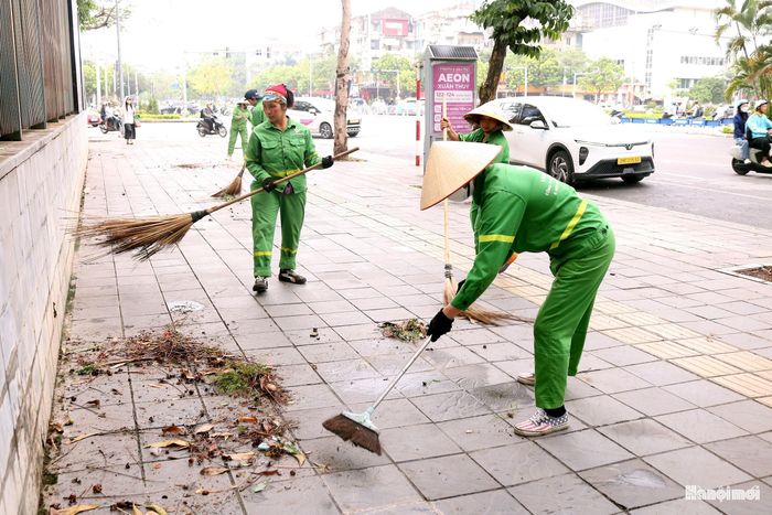 Lãnh đạo, nhân dân phường Nghĩa Đô phối hợp với đơn vị môi trường ra quân tổng vệ sinh. Ảnh: MT