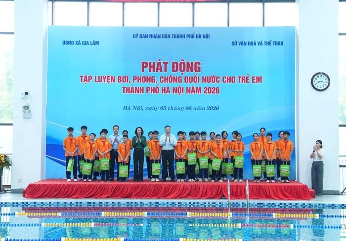 Các đồng chí lãnh đạo thành phố, xã Gia Lâm trao quà cho các em học sinh có hoàn cảnh khó khăn. Ảnh: Hoàng Anh