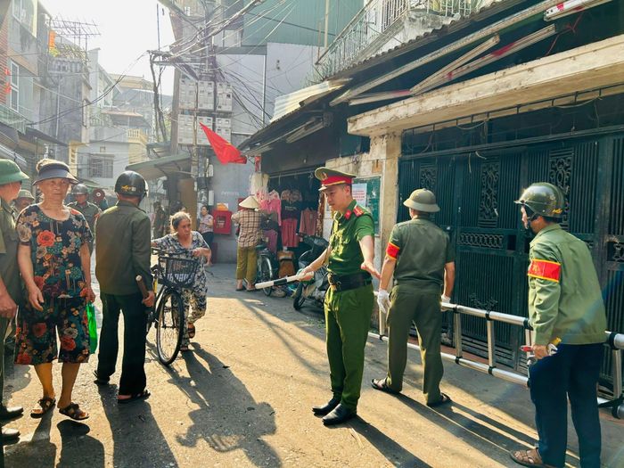 Công an phường phân luồng giao thông trong ngõ 240 Tân Mai. Ảnh: Trần Oanh.