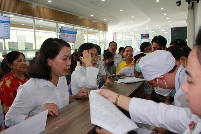 Lãnh đạo bệnh viện trực tiếp hỗ trợ người dân đăng ký khám sức khỏe tổng quát.