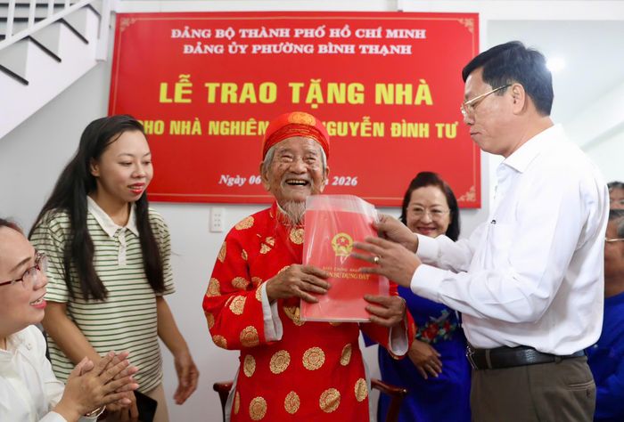 Ông Vũ Ngọc Tuất, Bí thư Đảng ủy phường Bình Thạnh, đại diện trao giấy chứng nhận quyền sử dụng đất đến cụ Tư. Ảnh: THANH THÙY 