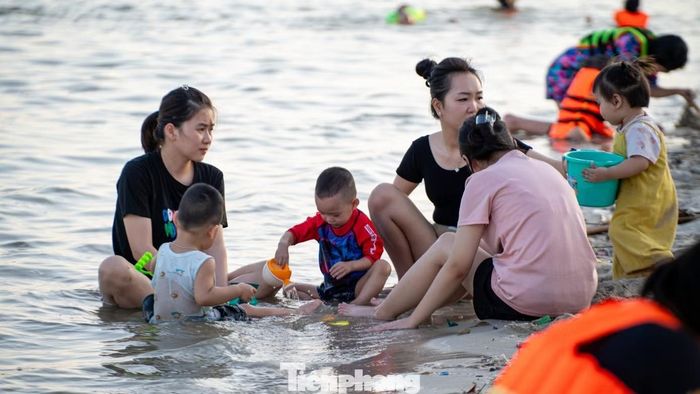  Các em nhỏ được bố mẹ đưa ra khu vực sát mép nước để tham gia các hoạt động vui chơi cùng gia đình và ngâm mình dưới nước. 