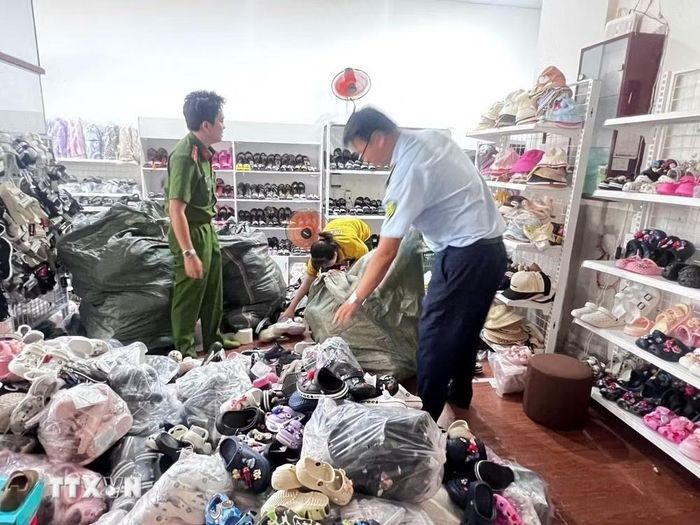  Các lực lượng chức năng phát hiện sản phẩm giày dép có dấu hiệu xâm phạm sở hữu công nghiệp của thương hiệu được bảo hộ lớn. Ảnh: TTXVN. 