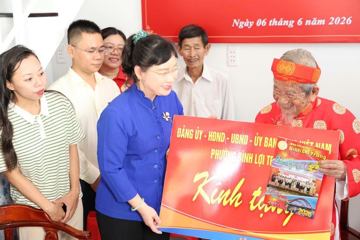 Phường Bình Lợi Trung tặng quà cho nhà nghiên cứu Nguyễn Đình Tư. Ảnh: PHAN ANH
