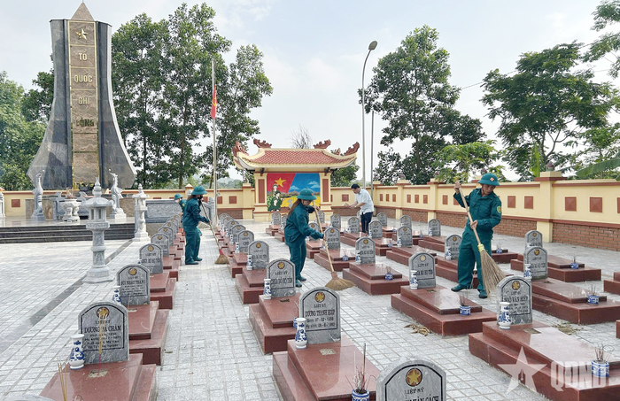 Lực lượng dân quân tham gia quét dọn nghĩa trang liệt sĩ tại xã Đại Từ. 