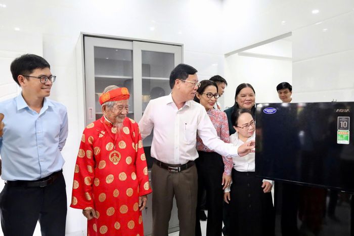  Các đại biểu cùng cụ Tư tham quan căn nhà mới. Ảnh: CẨM NƯƠNG 