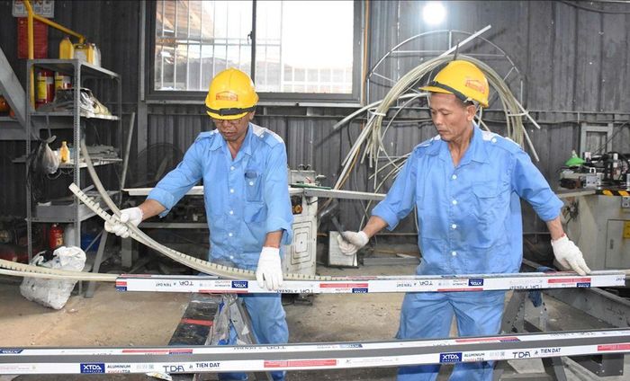 Công nhân Công ty TNHH Kỹ thuật cửa Huynh Đệ (phường Tam Thắng, TPHCM) trong giờ sản xuất (ẢNH: QUANG VŨ)