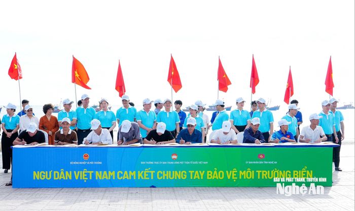 Các đại biểu chứng kiến ngư dân ký cam kết bảo vệ môi trường. Ảnh: Phạm Bằng
