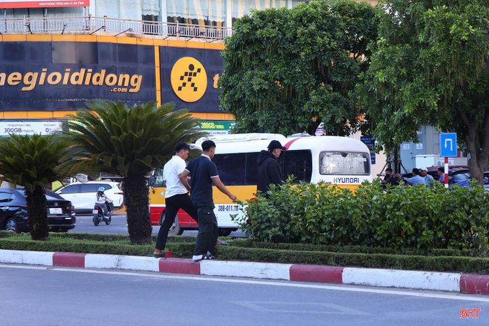 Nhiều người đi bộ vội vàng băng qua dải phân cách cứng, bất chấp dòng phương tiện đang lưu thông.
